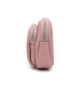 Side view of pink double-zippered purse showing textured leather and gold hardware