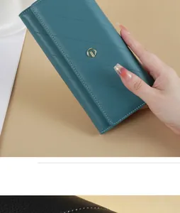 Detailed view of a teal quilted long leather wallet for women held in hand for scale