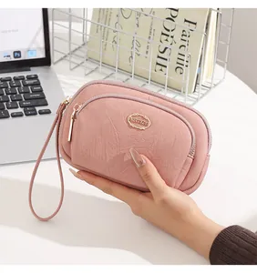 Close-up of pink double zipper wristlet pouch showing textured faux leather detail
