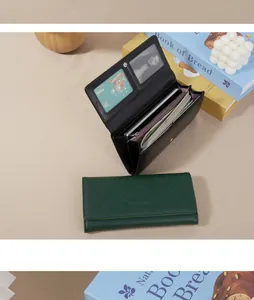 Detail view of women's green quilted wallet and black wallet interior with card slots
