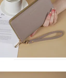 Primo piano di un elegante portafoglio lungo da donna in pelle con cinturino da polso