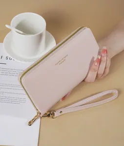 Primo piano di elegante portafoglio rosa lungo con cinturino da polso e texture