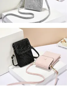 Drie verticale telefoon-crossbodytassen in zwart, roze en grijs met een textuurafwerking.