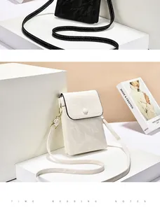 Detail van een witte verticale crossbody telefoontas met een subtiele marmeren textuur