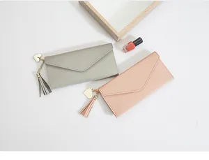 Carteras largas elegantes para mujer con dije de corazón y borla en gris y rosa.