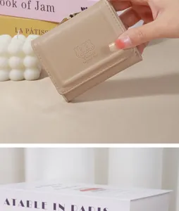 Close-up of beige Japanese style short wallet with cute embossed rabbit pattern detail