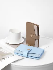Minimalist leather travel passport wallet with fabric detail and metal snap button