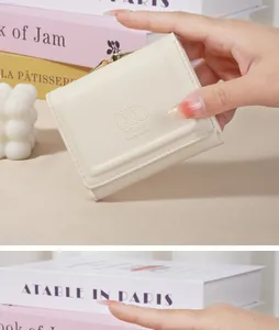 Close-up of cream Japanese style mini wallet with rabbit embossing held by hand detail