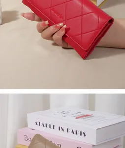 Close-up of red quilted leather long wallet held in hand showing texture