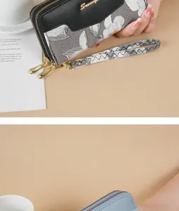 Detailed view of floral long wallet with dual gold zippers and a woven wristlet strap