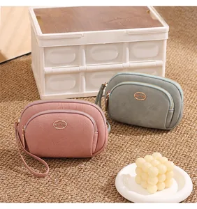 Detailed macro view of double-layer zipper clutch bags in pink and grey faux leather.