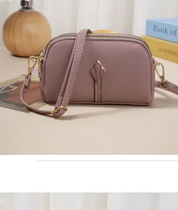 Vue détaillée d'un sac de téléphone en cuir mauve avec un ornement de tulipe dorée