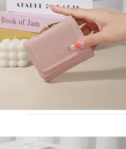 Close-up of a pastel pink short wallet featuring an adorable embossed rabbit pattern design
