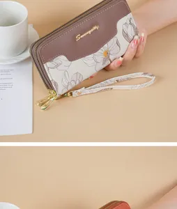 Detail view of long floral wallet with double zipper and matching wrist strap