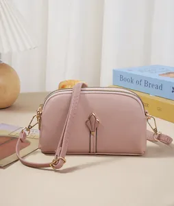 Élégant sac à bandoulière rose tulipe pour téléphone avec double fermeture éclair sur fond déco.