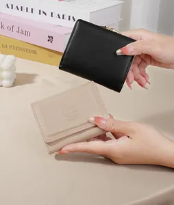 Close-up of compact Mori-style wallets with cute rabbit embossing in black and beige finishes.