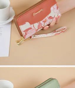 Detailed view of women's long clutch wallet featuring floral embroidery and wrist strap
