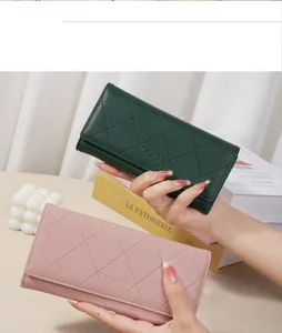 Detailed view of diamond quilted long wallets in dark green and dusty pink faux leather