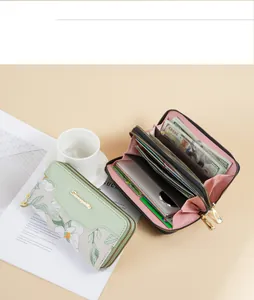 Detailed view of dual-zipper long wallet with embroidered floral pattern and interior compartments