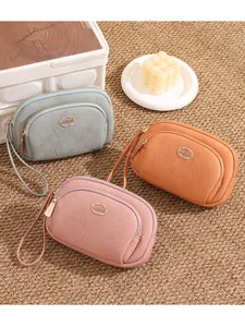 Three colorful women's double-zipper clutch bags shown on a soft textured carpet.