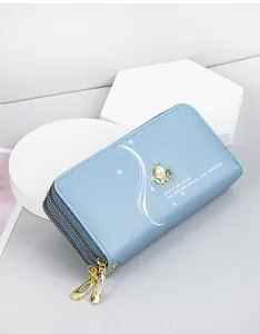 Close-up detail of a light blue long wallet for women with double zippers and a pearl bee charm
