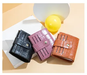 Detail view showing three crocodile pattern leather card wallets in black pink and tan