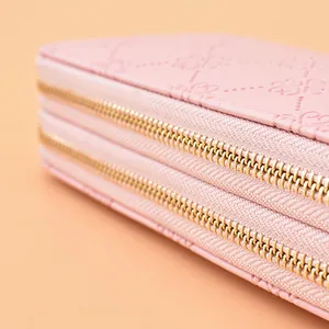 Vue détaillée d'un long portefeuille rose gaufré pour femme avec double fermeture éclair