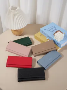 Elegant diamond-quilted long wallets for women in multiple colors on a beige tabletop.