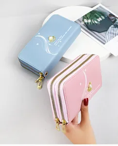 Detail view of light blue and pink double-zipper long wallets with elegant pearl accents