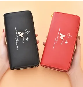 Detail view of black and red long wallets with elegant butterfly prints and dual zippers.