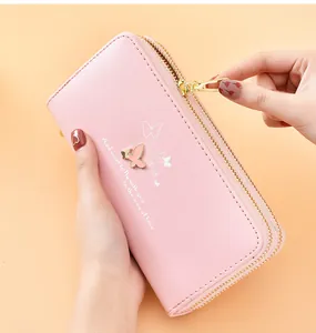 Close-up of pink long wallet with double zipper and butterfly ornament