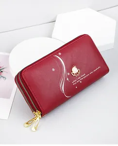 Detailed view of red leather long wallet with pearl charm and double zippers