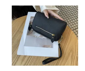 Detailed view of a black pebbled leather wristlet clutch bag for phone and coins