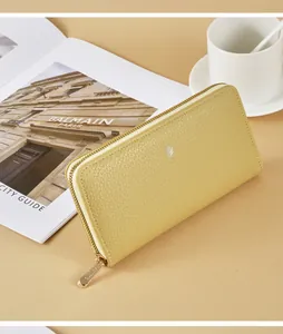 Detailed view of a yellow litchi grain long leather wallet in a minimalist lifestyle setting