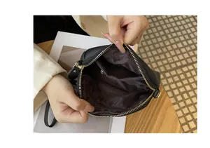 Close-up view showing the dark brown interior lining and pocket of black leather bag