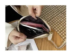 Close-up of small leather crossbody bag interior showing space for cash and smartphone