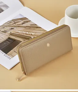 Close-up of a stylish khaki lychee pattern women's long zipper wallet on a desk.