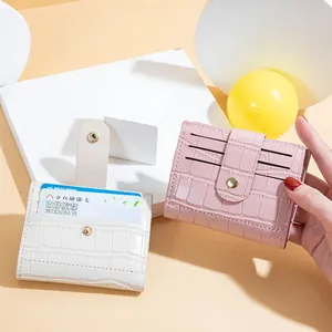 Compact women's wallet with stone pattern and snap button in pink and white.