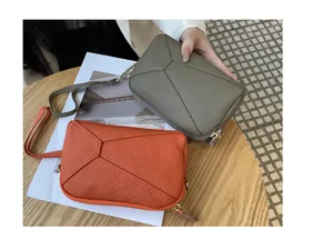 Genuine leather mini wristlet bag with geometric stitching pattern and zipper closure