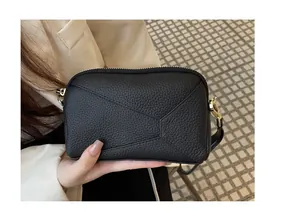 Close-up view of a premium black pebbled leather crossbody phone bag with gold hardware