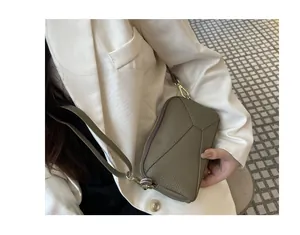 Close-up of olive green leather phone bag with geometric stitching and wrist strap