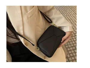 Premium black genuine leather mini crossbody phone bag styled with a modern beige blazer.