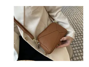 Close-up of brown genuine leather phone bag with pebbled texture and stitching detail