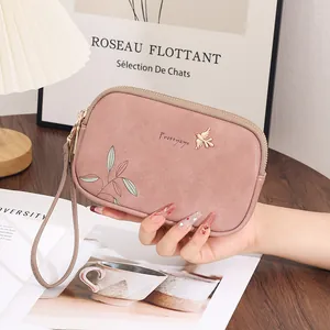 Elegant pink double zipper clutch featuring a bird logo and floral print wristlet strap.