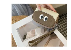 Primo piano del portamonete in pelle martellata con design occhi e cinturino da polso