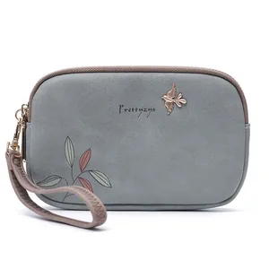 Close-up of elegant blue-grey clutch bag with leaf print and metal bird charm details