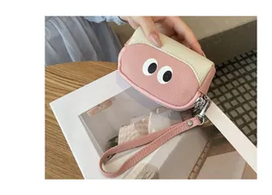 Primo piano del design con occhi a fumetto su un portamonete in pelle rosa con polsino.