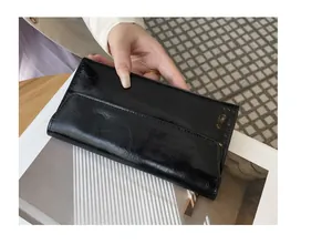 Vista detallada de una billetera larga negra delgada con elegante textura de cuero roto