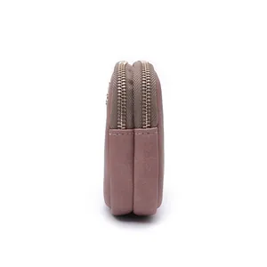 Side view detail of a dusty rose double zipper clutch bag and mobile phone wallet