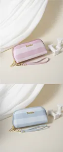 Dettaglio di pochette da donna a righe rosa e blu con eleganti cinturini da polso dorati